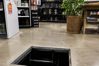 A 54-year-old client stepped into an unguarded open floor access hatch in a store.